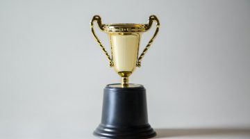 A golden trophy in front of a white background